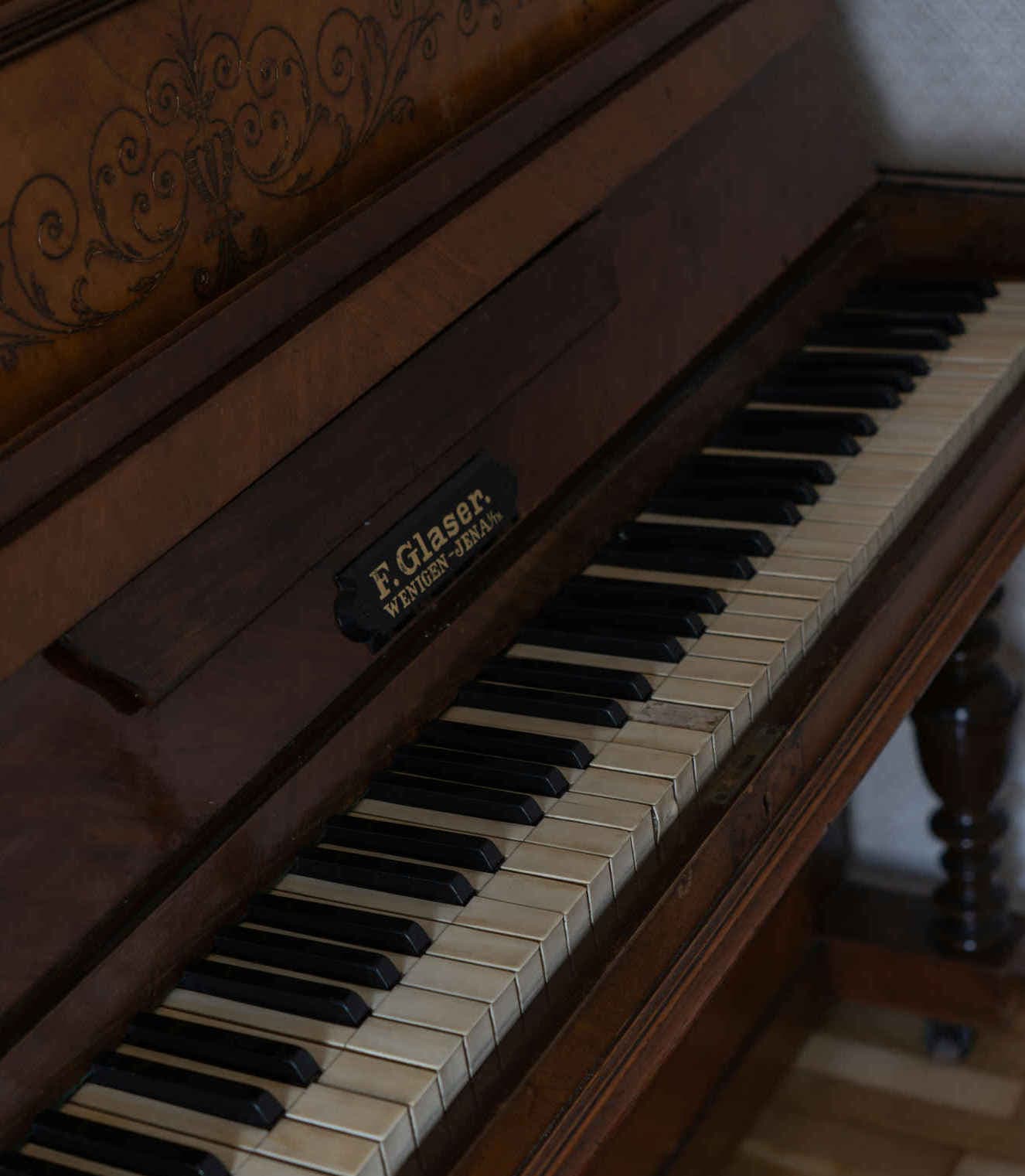 Close-up van een oude piano met een zichtbaar typeplaatje van de fabrikant