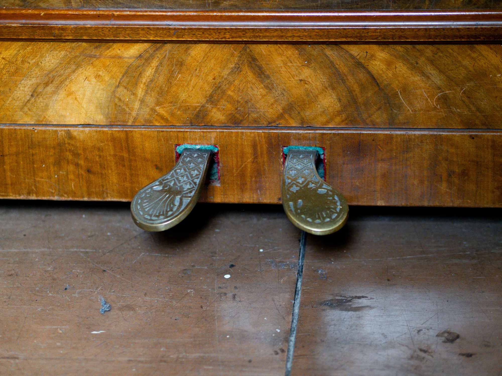 Due pedali di ottone decorati su un vecchio pianoforte verticale con cassa in mogano